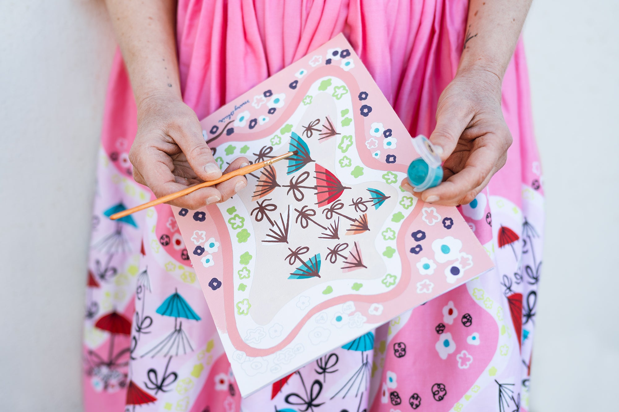 Person painting the Mary Blair Parasol's paint-by-number kit.