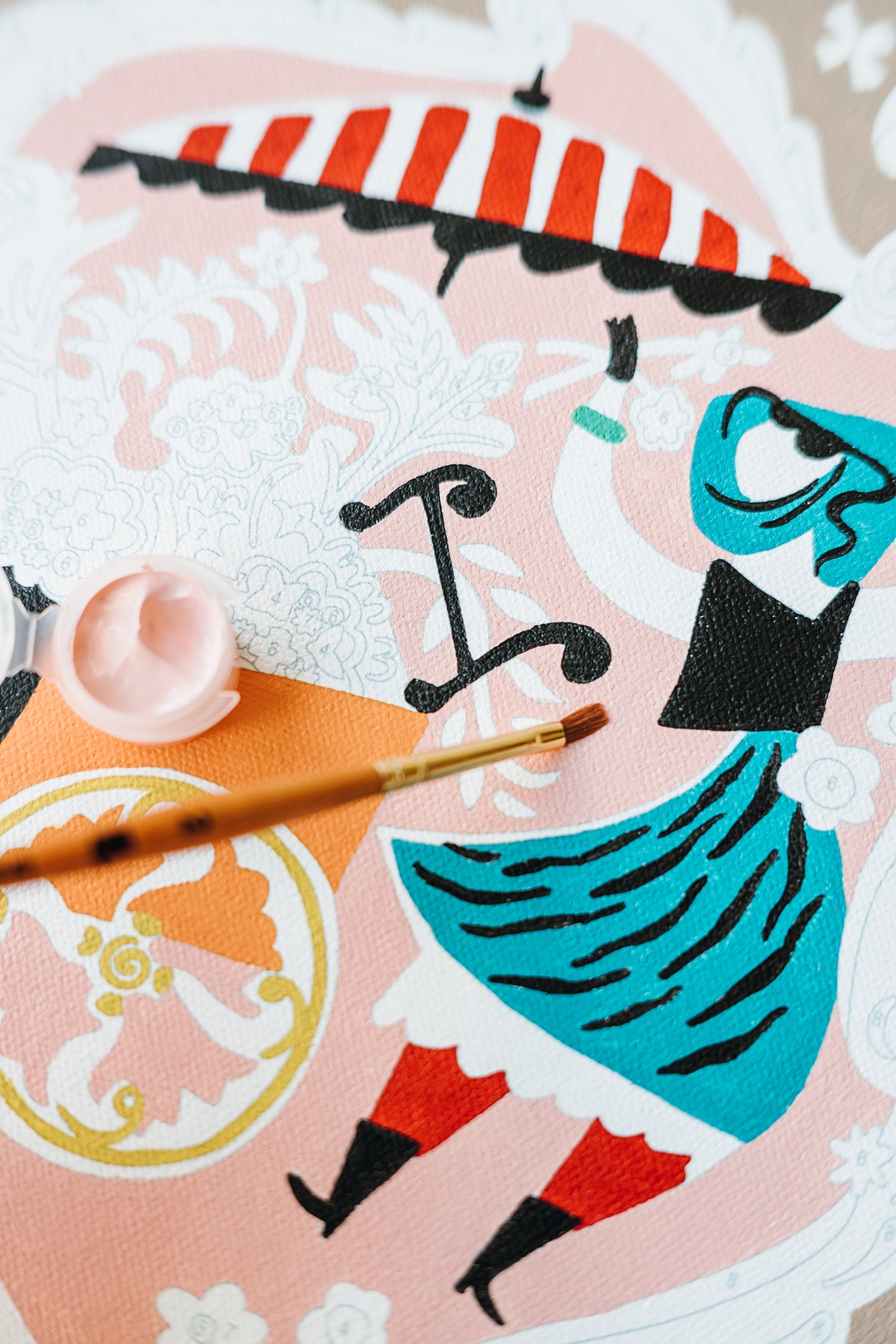 Close-up of Mary Blair’s Petal Peddler paint-by-number kit with flower cart, striped umbrella, paintbrush, and pink paint pot.