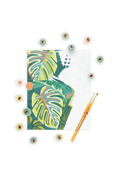 Vintage Verde paint-by-number kit with tropical leaf design, 12 acrylic paint pots, and two paintbrushes on white background.