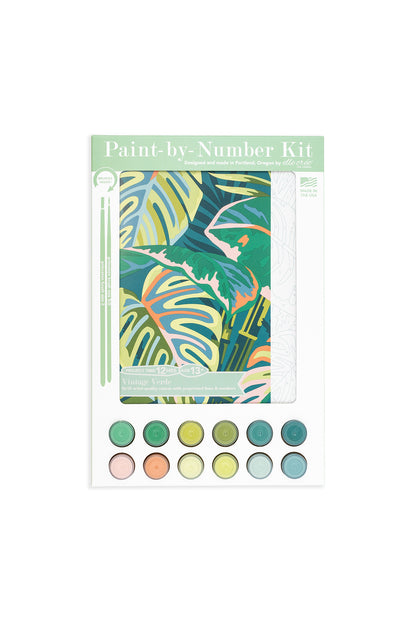 Vintage Verde paint-by-number kit packaging featuring tropical leaf artwork, 12 acrylic paint colors, and brushes, designed by Elle Crée.