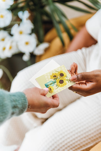 Yellow Sunflowers mini card and envelope being handed to someone